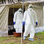 Health workers rinse their feet in bleach when leaving a tent for Ebola patients. Our blogger says the world should rinse out its prejudice and not repeat the same mistakes made with AIDS 30 years ago.