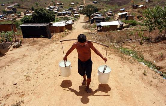 A man hauls water at the Chico Mendes landless peasant camp in Pernambuco, Brazil. Credit: Alejandro Arigón/IPS