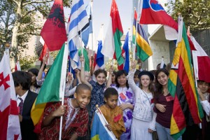 Young students in traditional dress waive their national flags during the observance of the International Day of Peace at United Nations headquarters in 2007 | UN Photo/Paulo Filgueiras